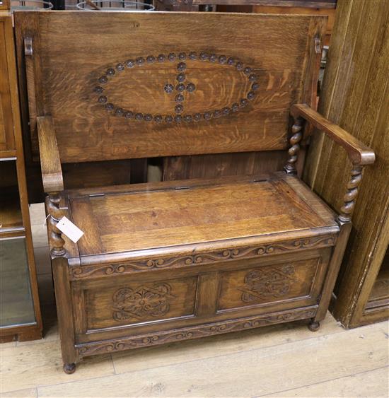 A 1920s oak monks bench W.106cm